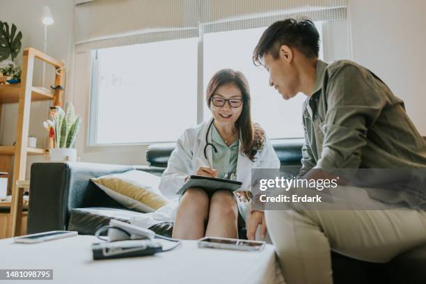 private appointment of surgeon doctor with transgender man patient at home. - southeast asian ethnicity stock pictures, royalty-free photos & images