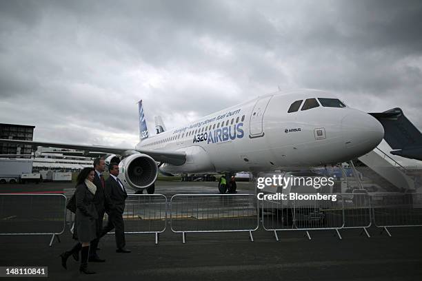Visitors pass an Airbus SAS A320 aircraft on the second day of the Farnborough International Air Show in Farnborough, U.K., on Tuesday, July 10,...