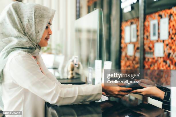 businesswoman paying contactless at hotel reception - veil isolated stock pictures, royalty-free photos & images