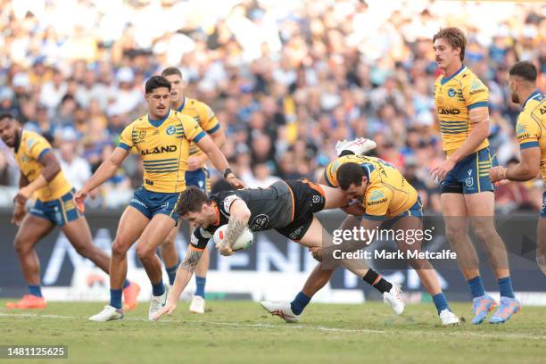 John Bateman of the Wests Tigers is tackled during the round six NRL match between Wests Tigers and Parramatta Eels at Accor Stadium on April 10,...