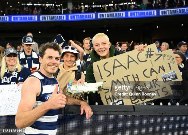 Isaac Smith of the Cats gives his boots to a fan in the crowd during the round four AFL match between Geelong Cats and Hawthorn Hawks at Melbourne...