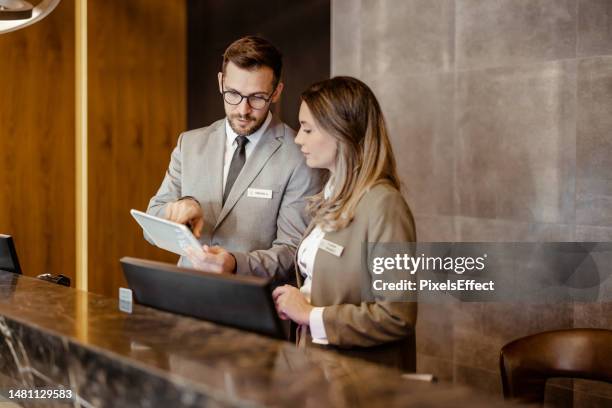 hotelangestellter nutzt digitales tablet - hotel stock-fotos und bilder