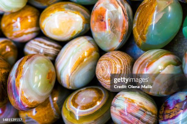 close-up of polished colofrul agate stones cut in egg shape. different multi colored minerals and semi precious stones in flat lay style - jade close stock pictures, royalty-free photos & images