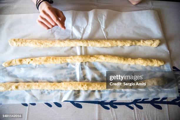 rolling chilled dough into long ropes to make italian easter bread (pane di pasqua) - braided bread stock pictures, royalty-free photos & images