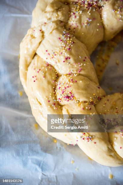 raw braided dough scattered with coloured sprinkles over italian easter bread (pane di pasqua) - braided bread stock pictures, royalty-free photos & images