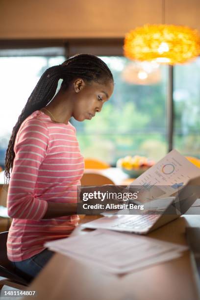 woman working on her finances at home - kosten besparen stockfoto's en -beelden