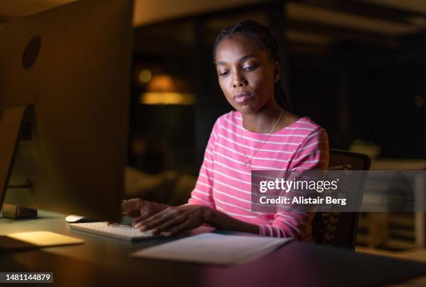 young woman working from home at night - avondschool stockfoto's en -beelden