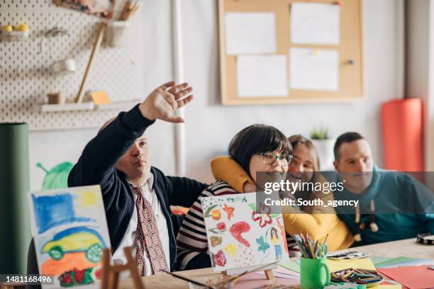 group of people with down syndrome in creative art work shop - adult coloring stock pictures, royalty-free photos & images
