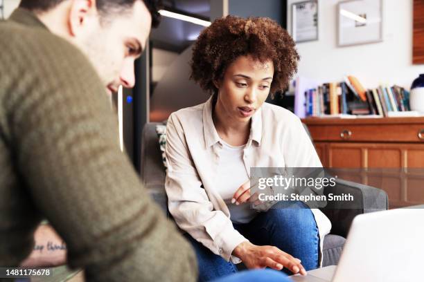 businessman discussing with female colleague in modern office - colleagues stock pictures, royalty-free photos & images