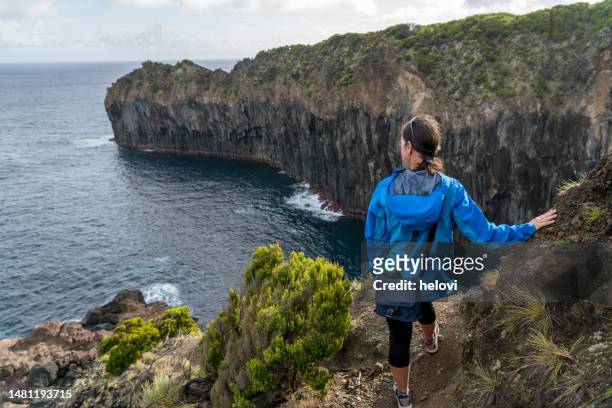woman at the edge of volcano's cliff, terceira, azores - azores people stock pictures, royalty-free photos & images