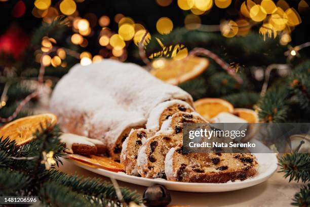 christmas stollen on wooden background. traditional christmas german dessert cut into pieces. - fruitcake stock-fotos und bilder