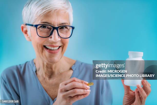 senior woman taking dietary supplement - vitamins and minerals stock pictures, royalty-free photos & images