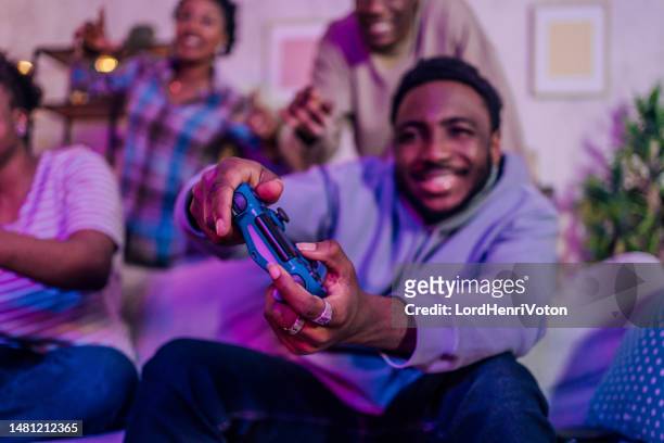 friends playing video games at night - adrenaline junkie stock pictures, royalty-free photos & images