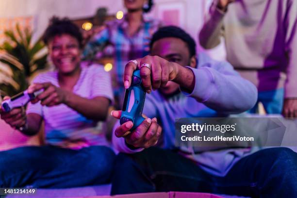 friends playing video games at night - adrenaline junkie stock pictures, royalty-free photos & images