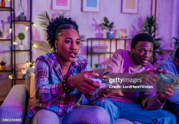 friends playing video games at night - adrenaline junkie stock pictures, royalty-free photos & images