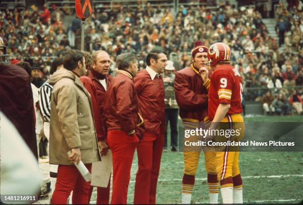 With unidentified others, American football coach George Allen , of the Washington Redskins talks with his team's quarterbacks Bill Kilmer and Sonny...