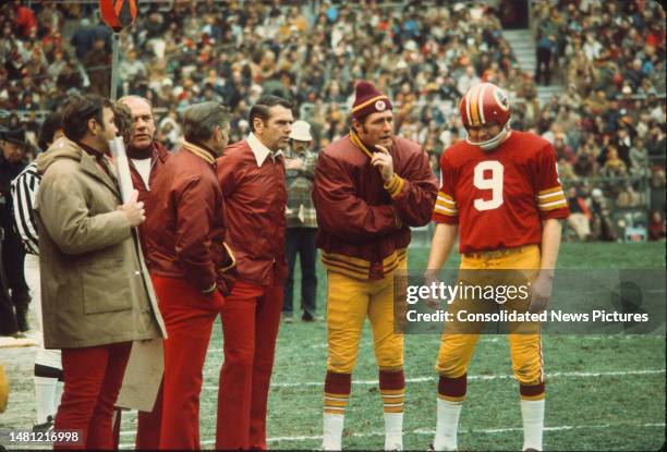 With unidentified others, American football coach George Allen , of the Washington Redskins talks with his team's quarterbacks Bill Kilmer and Sonny...