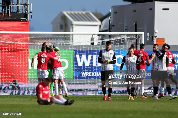 Ben Foster of Wrexham is congratulated by team mates after the final whistle after saving a 97th minute Notts County penalty in the Vanarama National...