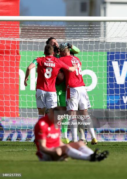 Ben Foster of Wrexham is congratulated by team mates after the final whistle after saving a 97th minute Notts County penalty in the Vanarama National...