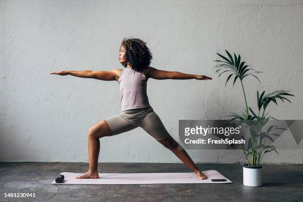 a beautiful woman doing her daily workout - black woman yoga stock pictures, royalty-free photos & images