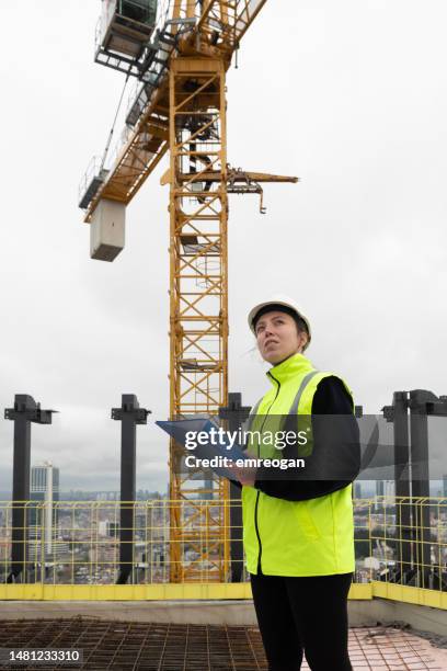 female architect looking at project on construction site - construction site stock pictures, royalty-free photos & images