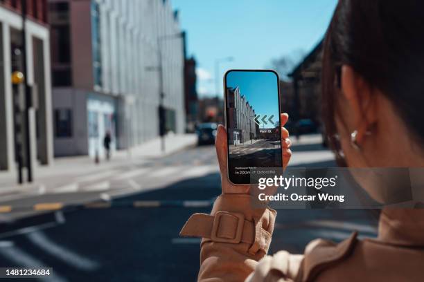young woman finding direction in the city with augmented reality on smartphone - toegevoegde realiteit stockfoto's en -beelden