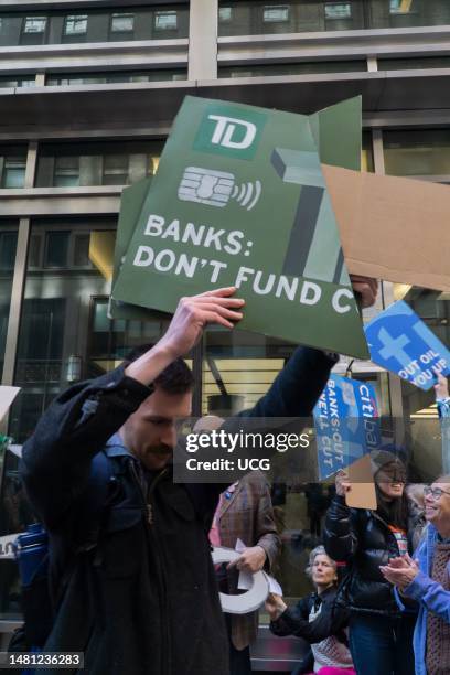 Climate activists hold up pieces of giant prop cut up credit cards at rally and protest outside a JP Morgan Chase and Co office during Stop Dirty...