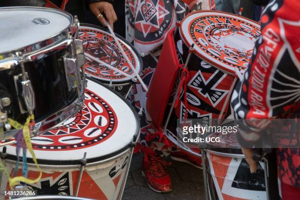 Drums but only 2 hands and 3 drumsticks are visible, as 2 members of the Batala New York all-women Black-led percussion ensemble play drums at Stop...