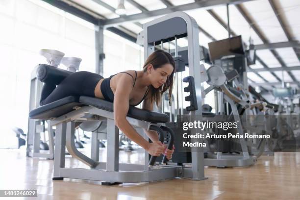 mulher que usa equipamentos de ginástica para fortalecer pernas e nádegas - female backside - fotografias e filmes do acervo