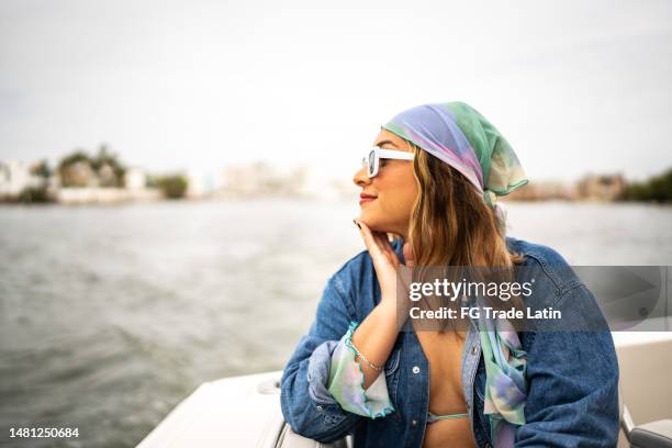 young woman relaxing and contemplating on a yacht - bandana stock pictures, royalty-free photos & images