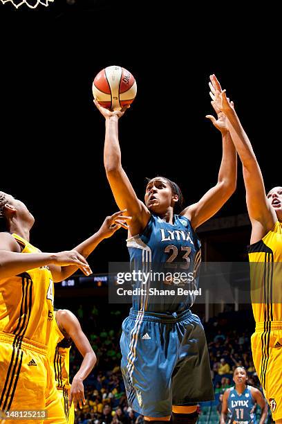 Maya Moore of the Minnesota Lynx drives past Kayla Peterson and Amber Holt of the Tulsa Shock during the WNBA game on July 10, 2012 at the BOK Center...