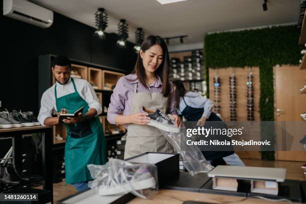 la vendeuse emballe les chaussures dans une boîte - wrapping paper stock photos et images de collection