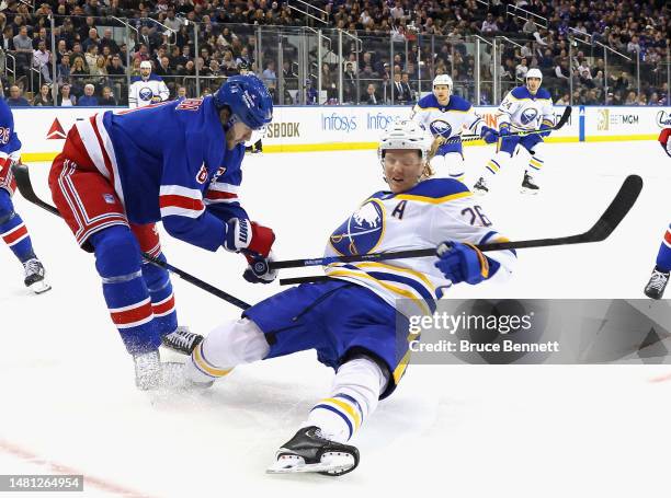 Rasmus Dahlin of the Buffalo Sabres is hit by Jacob Trouba of the New York Rangers during the first period at Madison Square Garden on April 10, 2023...