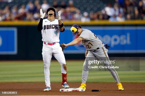 Ketel Marte of the Arizona Diamondbacks celebrates his double as Willy Adames of the Milwaukee Brewers applies the late tag in the first inning at...