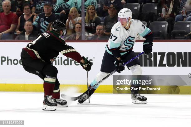 Morgan Geekie of the Seattle Kraken passes against Juuso Valimaki of the Arizona Coyotes during the first period at Mullett Arena on April 10, 2023...