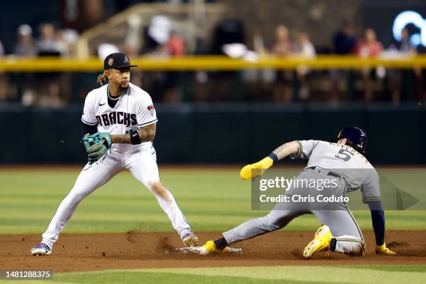 Ketel Marte of the Arizona Diamondbacks turns a double play over Garrett Mitchell of the Milwaukee Brewers during the fifth inning at Chase Field on...