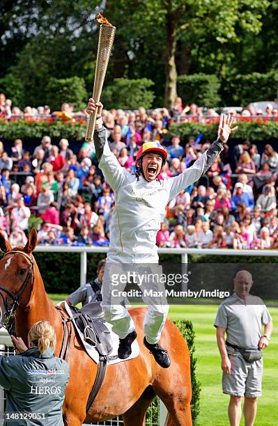 Frankie Dettori performs his flying dismount from former race horse Monsignor after carrying the Olympic torch around the parade ring on day 53 of...