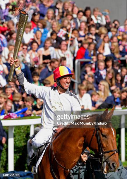 Frankie Dettori carries the Olympic torch whilst riding former race horse Monsignor around the parade ring on day 53 of the London 2012 Olympic Torch...