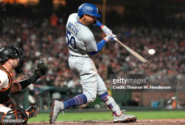 Mookie Betts of the Los Angeles Dodgers hits an RBI single scoring James Outman against the San Francisco Giants in the top of the seventh inning at...
