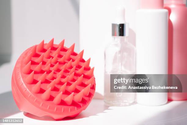 means and massager for the care of the scalp and hair in front of the mirror - massager stock pictures, royalty-free photos & images