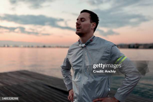 happy man breathing deeply fresh air by the seashore - fresh air breathing stockfoto's en -beelden