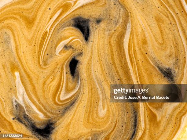 full frame, textures of the cream of a cup of fresh coffee. - chocolate swirls stock-fotos und bilder