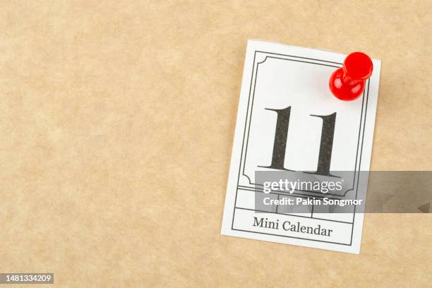 mini calendar with the date 11th pinned to a light yellow background. - number 11 stock pictures, royalty-free photos & images