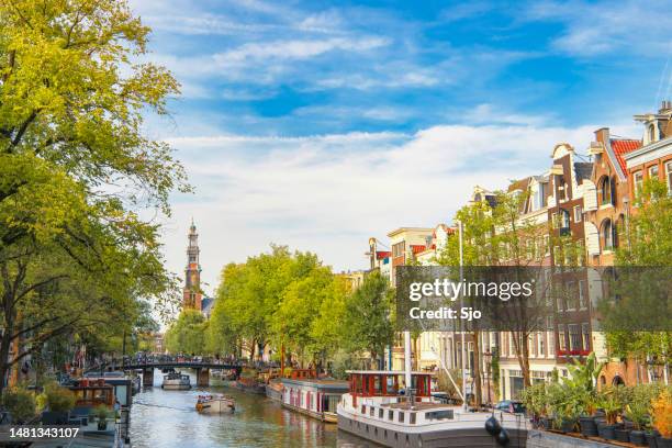 amsterdam canal with house boats and merchant's houses in the downtown canal district during summer - amsterdam stock pictures, royalty-free photos & images