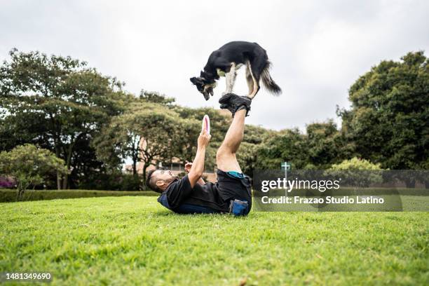 animal trainer man teaching tricks for dog at public park - animal tricks stock pictures, royalty-free photos & images