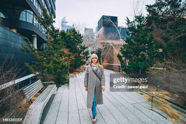 mujer caminando por el parque high line manhattan nueva york ciudad de ee.uu. - chelsea new york fotografías e imágenes de stock