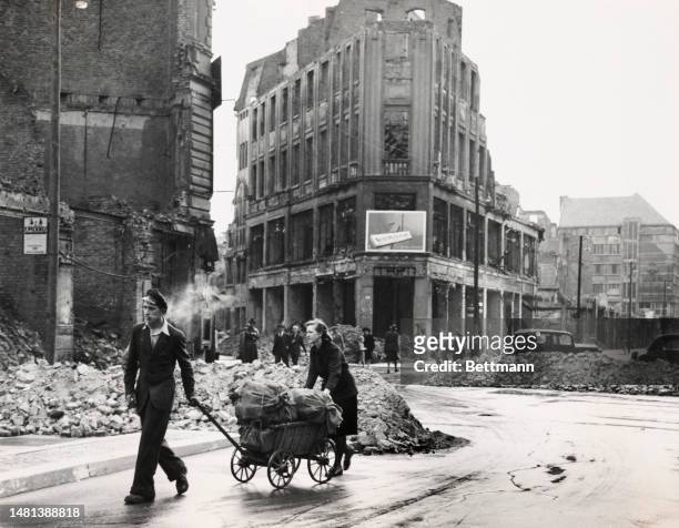 The one commodity getting through the Berlin blockade legally is potatoes. This Berlin couple is bringing several bags of them into the Western...