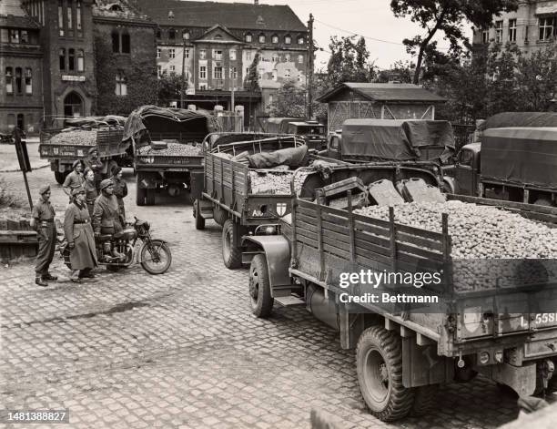 Army trucks loaded with potatoes and other food items are shown en route to Allied food distribution centres in Berlin, circa August 22nd, 1945.