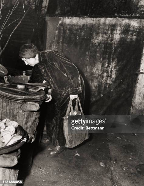 Woman going through bins to look for food in Berlin on December 12th, 1947. She reportedly said 'No food, no food'.