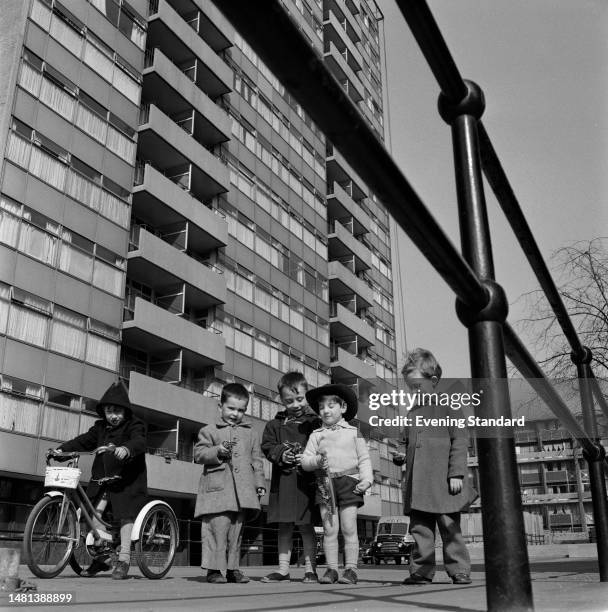 Group of children playing with their toy guns in outside Great Arthur House on the Golden Lane housing estate, London, April 30th, 1960.